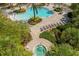 Aerial view of a unique shaped pool and jacuzzi, surrounded by lounge chairs, tables, lush landscaping, and tropical plants at 1031 Marcello Blvd, Kissimmee, FL 34746