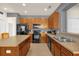 Functional kitchen with black appliances, wooden cabinetry, and a double sink at 1031 Marcello Blvd, Kissimmee, FL 34746