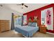 Cozy main bedroom with red accent wall, decorated with Mickey Mouse themed decor at 1031 Marcello Blvd, Kissimmee, FL 34746