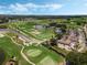 Beautiful aerial view of the golf course, with ponds, lush greenery, and nearby community buildings at 1089 Blue Jay Dr, Davenport, FL 33837