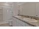 Bathroom featuring dual sinks, granite countertops, and a shower with white tile surround at 1089 Blue Jay Dr, Davenport, FL 33837