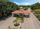 Gated community entrance featuring a terracotta roof, stone accents, a water feature and manicured landscaping at 1089 Blue Jay Dr, Davenport, FL 33837