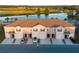 Exterior of townhomes featuring garages, driveways, neutral stucco, and picturesque water views at 1089 Blue Jay Dr, Davenport, FL 33837