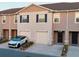 Townhome featuring garage, front door, neutral stucco, small landscaped front yard, and nearby houses at 1089 Blue Jay Dr, Davenport, FL 33837
