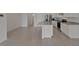 View of the kitchen with a granite topped island, white cabinets, tile floor, and stainless-steel appliances at 1089 Blue Jay Dr, Davenport, FL 33837
