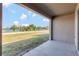 Covered patio offers a beautiful lake view surrounded by palm trees and a lush lawn area at 1089 Blue Jay Dr, Davenport, FL 33837