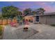 Backyard is a paver paradise featuring a fire pit, above ground pool, lounge chairs, and cabana at 1105 Tivoli Drive, Deltona, FL 32725