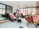 Enclosed sunroom offering various seating options for relaxation, from rocking chairs to cushioned loungers at 1105 Tivoli Drive, Deltona, FL 32725