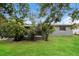 A backyard with lush grass, a fence, and privacy from mature trees at 1108 Jordan Ave, Orlando, FL 32809