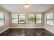 Bright bedroom with three windows for natural light and wood-look floors at 1108 Jordan Ave, Orlando, FL 32809