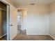 A well-lit bedroom with neutral tones, carpet flooring, and an open closet for storage at 1108 Jordan Ave, Orlando, FL 32809