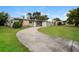 Wide shot of a single-story home with a long driveway and lush green lawn at 1108 Jordan Ave, Orlando, FL 32809