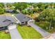 Aerial view of home with a gray roof, white siding, gray brick driveway, green lawn, and mature landscaping at 1109 Naples Dr, Orlando, FL 32804