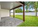 A spacious backyard features a covered patio with a brick floor, a large lawn and a privacy fence at 1109 Naples Dr, Orlando, FL 32804