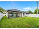 A spacious backyard with a covered patio, a large lawn, a privacy fence, and views of the house at 1109 Naples Dr, Orlando, FL 32804