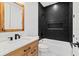 Modern bathroom with black herringbone tile, wooden vanity, and tub at 1109 Naples Dr, Orlando, FL 32804
