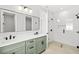 Modern bathroom featuring double vanity with sage green cabinets, black fixtures, and a glass-enclosed shower at 1109 Naples Dr, Orlando, FL 32804