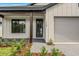 Exterior of home with board and batten siding, brick pathway, gray driveway, and a manicured lawn at 1109 Naples Dr, Orlando, FL 32804