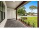 Inviting front porch with brick flooring, white siding, dark trim, and professionally landscaped garden at 1109 Naples Dr, Orlando, FL 32804