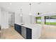 Modern kitchen featuring large island with white counters, stainless appliances, and white and navy cabinets at 1109 Naples Dr, Orlando, FL 32804