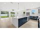 Modern kitchen featuring large island with white counters, stainless appliances, and white and navy cabinets at 1109 Naples Dr, Orlando, FL 32804