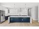 Modern kitchen featuring large island with white counters, stainless appliances, and white and navy cabinets at 1109 Naples Dr, Orlando, FL 32804