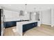 Modern kitchen features a large island, white countertops, white and navy cabinets, and stainless steel appliances at 1109 Naples Dr, Orlando, FL 32804