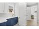Modern laundry room features blue cabinets, white countertops, and a gold faucet at 1109 Naples Dr, Orlando, FL 32804