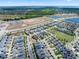 Expansive aerial view showcases a vibrant community with houses, roads, lakes, green spaces and community amenities at 11927 Charades St, Orlando, FL 32832