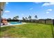 Beautiful backyard with a sparkling pool featuring a waterfall, lush lawn, and a private fence at 11927 Charades St, Orlando, FL 32832