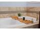 Close-up of a bathtub with decor and tiled walls in this bright bathroom at 11927 Charades St, Orlando, FL 32832