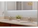 Bathroom featuring double sinks with stone countertop and large mirror with decorative lighting at 11927 Charades St, Orlando, FL 32832