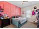Charming bedroom featuring a decorative pink wall and a comfortable daybed with plush pillows at 11927 Charades St, Orlando, FL 32832