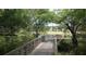 Scenic community walkway features a wooden bridge leading to a serene lake surrounded by lush greenery at 11927 Charades St, Orlando, FL 32832