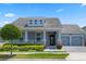 Charming home showcasing a manicured front yard, covered porch, and a two-car garage at 11927 Charades St, Orlando, FL 32832