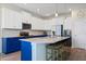 Bright kitchen featuring white cabinets, blue island, pendant lighting, and stainless steel appliances at 11927 Charades St, Orlando, FL 32832