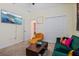 Relaxing living room with a comfortable orange chair, green sofa, television, and large closet at 11927 Charades St, Orlando, FL 32832