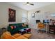 Cozy living room with a green sofa, orange chairs, Bob Marley art, and a home office setup at 11927 Charades St, Orlando, FL 32832
