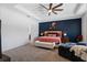Spacious Primary bedroom featuring a tray ceiling, ceiling fan, lounge chair, and neutral carpet at 11927 Charades St, Orlando, FL 32832