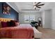Large Primary bedroom featuring a tray ceiling, ceiling fan, and a comfortable lounge chair at 11927 Charades St, Orlando, FL 32832