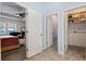 Open bedroom view featuring a ceiling fan, large windows, and access to a walk-in closet and powder room at 11927 Charades St, Orlando, FL 32832