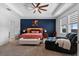 Primary bedroom with a tray ceiling, ceiling fan, upholstered headboard, and a comfortable lounge chair at 11927 Charades St, Orlando, FL 32832