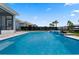 Inviting backyard pool featuring a modern design, a tranquil waterfall, and lush landscaping creating a serene retreat at 11927 Charades St, Orlando, FL 32832