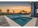 Beautiful backyard pool with integrated spa and serene waterfall feature, set against a colorful sunset at 11927 Charades St, Orlando, FL 32832