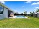 Backyard pool with a water feature, modern chair, black fence, and green grass at 11927 Charades St, Orlando, FL 32832