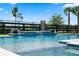 Close-up of a modern swimming pool featuring a tiled waterfall feature and an attractive black fence for privacy at 11927 Charades St, Orlando, FL 32832