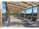 Relaxing poolside lounge area features comfortable seating beneath a shaded pergola, overlooking the tennis court at 11927 Charades St, Orlando, FL 32832