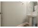 Modern powder room featuring a sink, round mirror, and white walls at 11927 Charades St, Orlando, FL 32832
