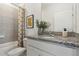 Well-lit bathroom featuring a granite countertop, modern fixtures, and shower-tub combination at 1240 Blue Daze Ln, Eustis, FL 32726
