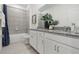 Modern bathroom features a double vanity with granite countertop and a tiled shower-tub combo at 1240 Blue Daze Ln, Eustis, FL 32726